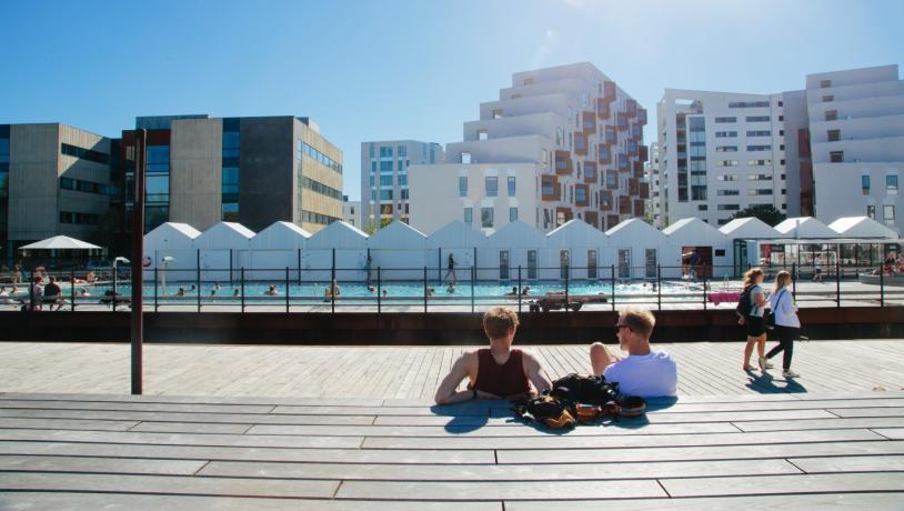 People enjoying the sun beside the harbour bath in Odense, Denmark