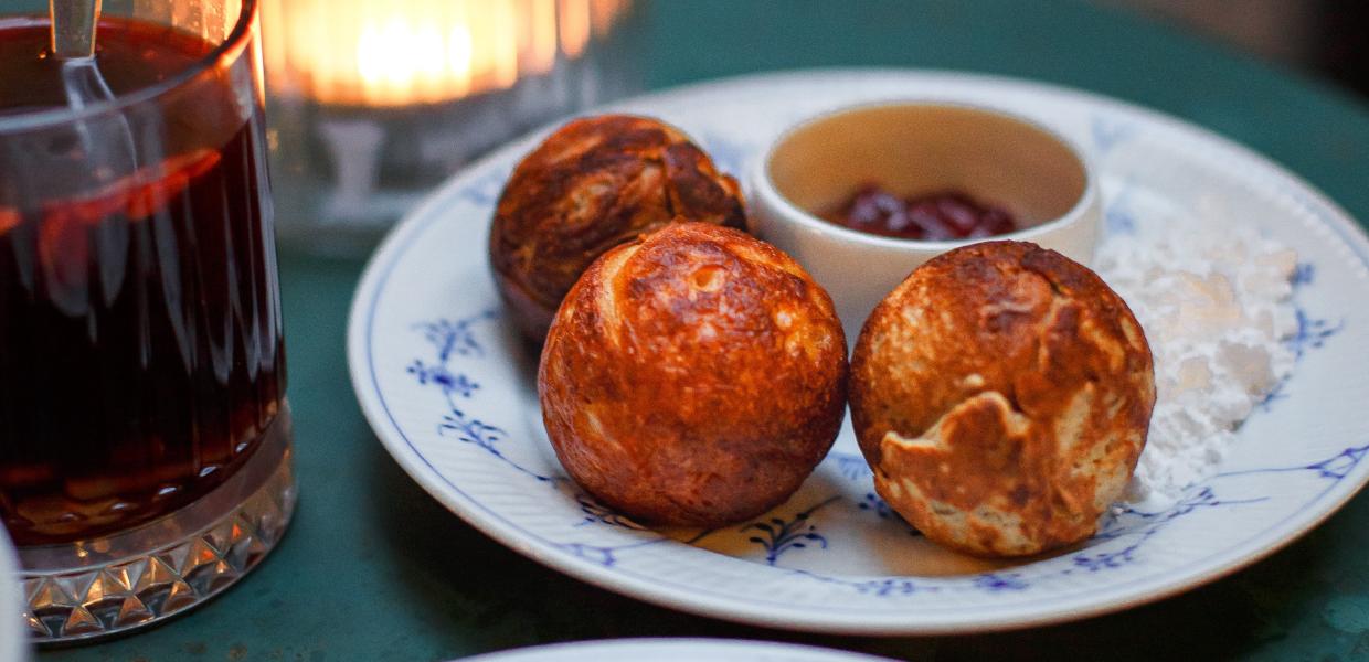 Der dänische Klassiker Æbleskiver auf einem Teller mit Gløgg