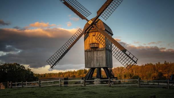 A windmill stands tall on a field