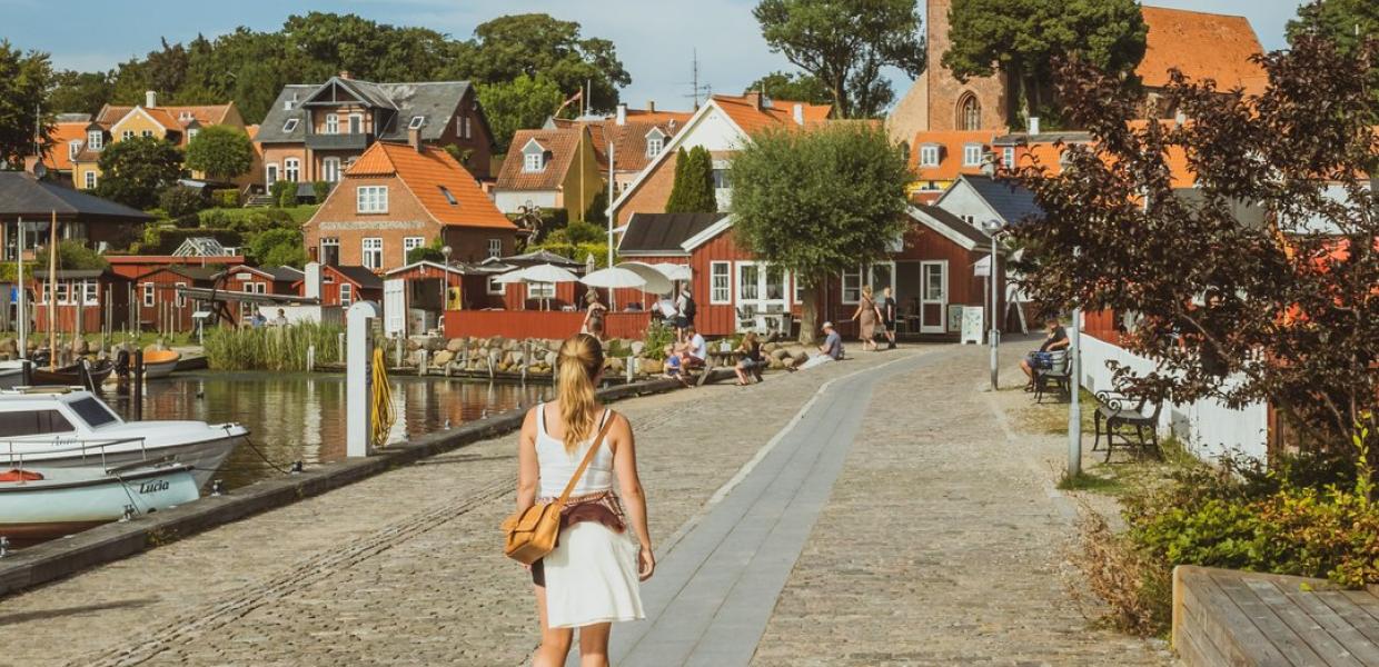 A woman walks beside the harbour in Nysted, Lolland Falster, Denmark