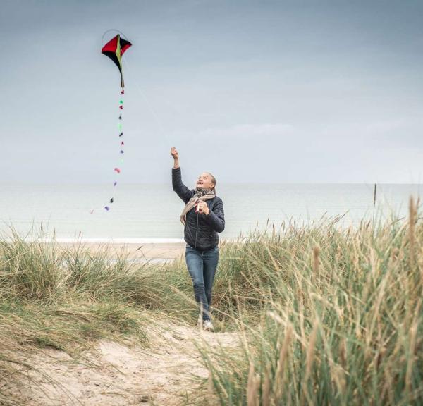 Child running with kite at beach at West Coast, Denmark