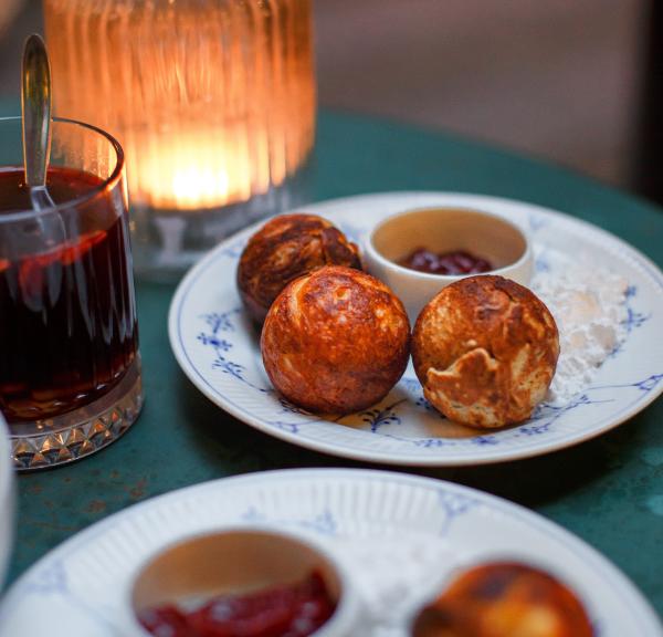 Der dänische Klassiker Æbleskiver auf einem Teller mit Gløgg