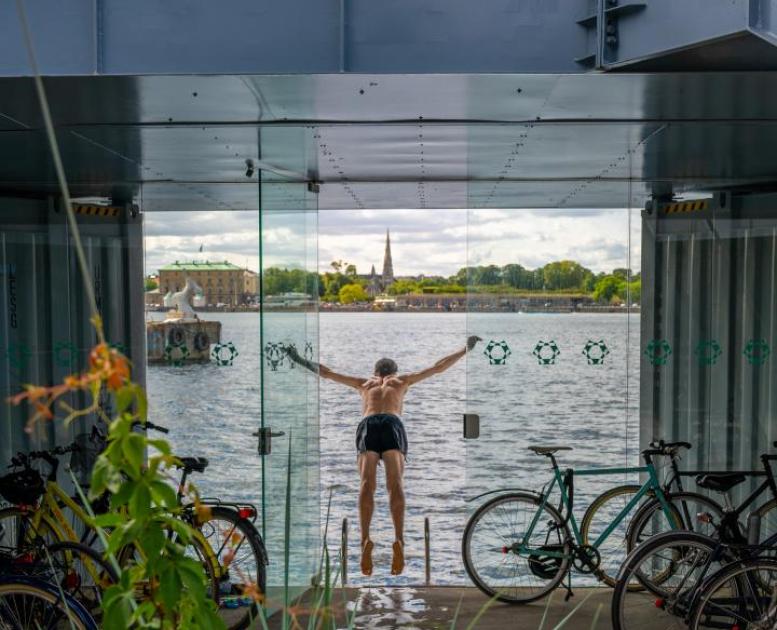 A man swims from the Urban Rigger student housing block designed by Bjarke Ingels Group in Copenhagen, Denmark