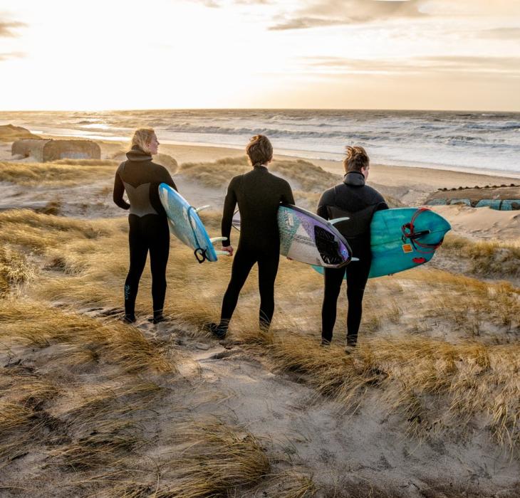 Tre surfere på Klitmøller strand i Cold Hawaii i Danmark